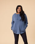 side view of mother wearing hooded pregnancy & nursing sweatshirt in blue with Cadenshae logo 