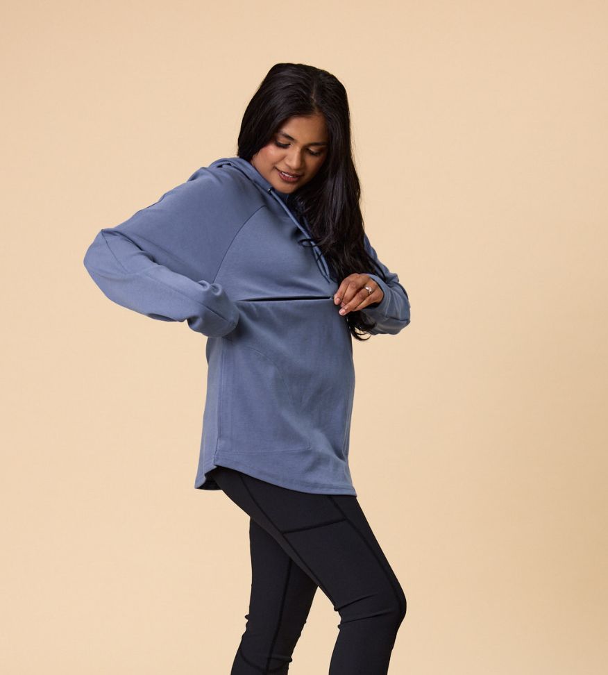 mother demonstrating the nursing function of a nursing hooded sweatshirt