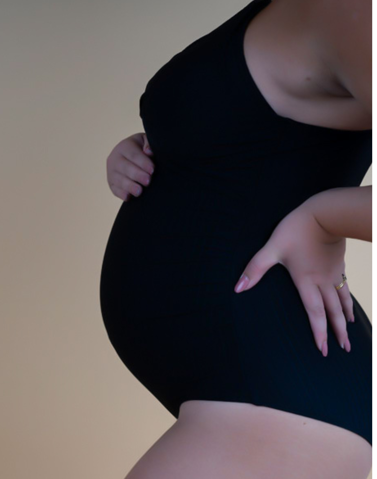 Side view of pregnant mother wearing black one-piece nursing swimsuit 