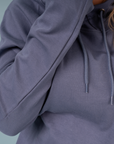 back view of woman wearing light blue jumper, showcasing contract print trim in the hood