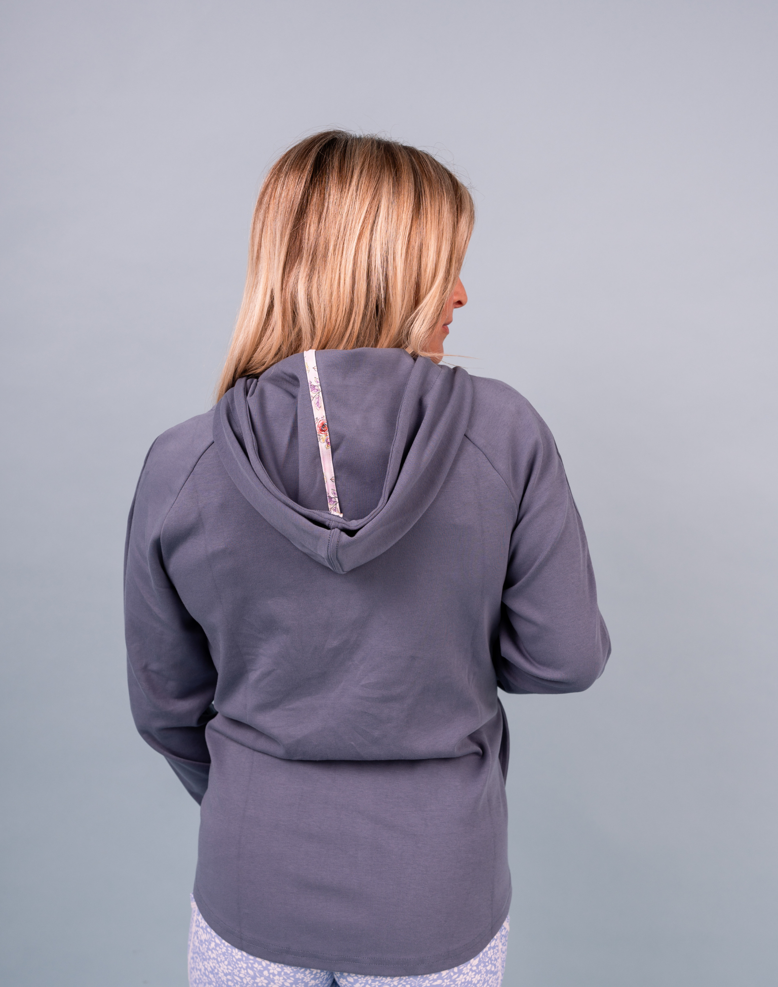 Woman wearing light blue sweatshirt with drawstring hood 