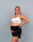 Front view of pregnant mother wearing a white supportive breastfeeding bra