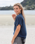 Active mother at the beach wearing charlotte nursing t-shirt in blue