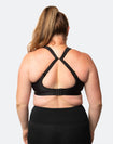 Back view of breastfeeding mum using the fastening clip on the back of a plus size nursing bra