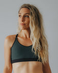 woman wearing dark green wire free exercise crop bra for moderate intensity exercise